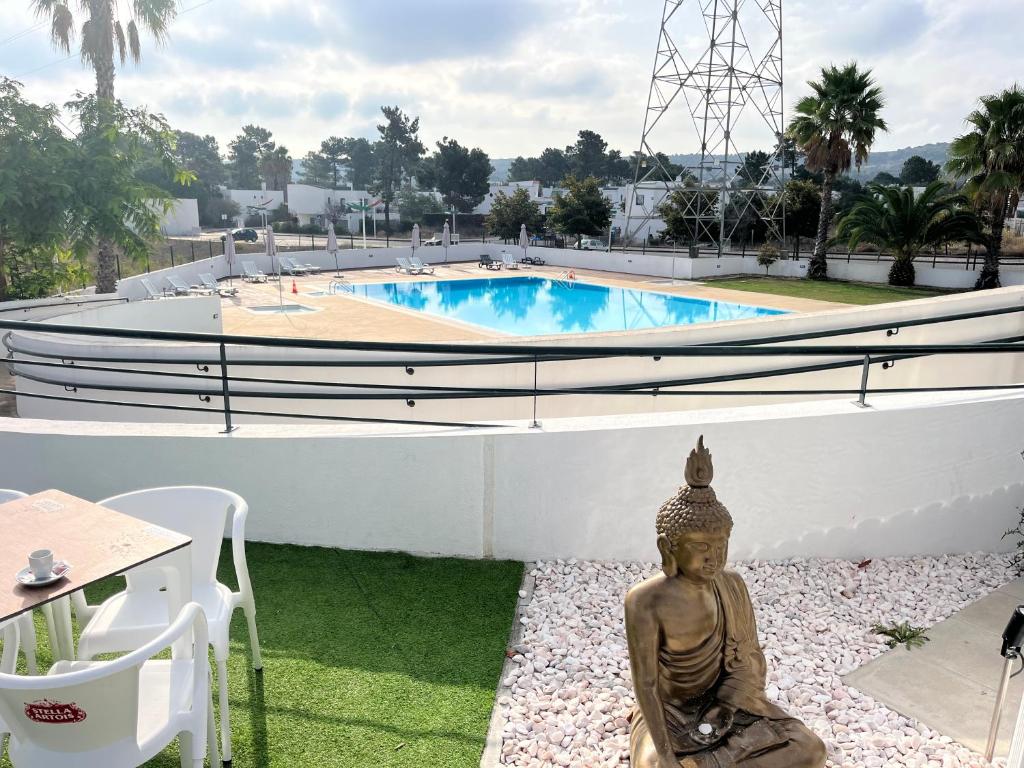 eine Statue vor einem Pool in der Unterkunft Nice Resort Studio Holidays Family in Palmela in Quinta do Anjo