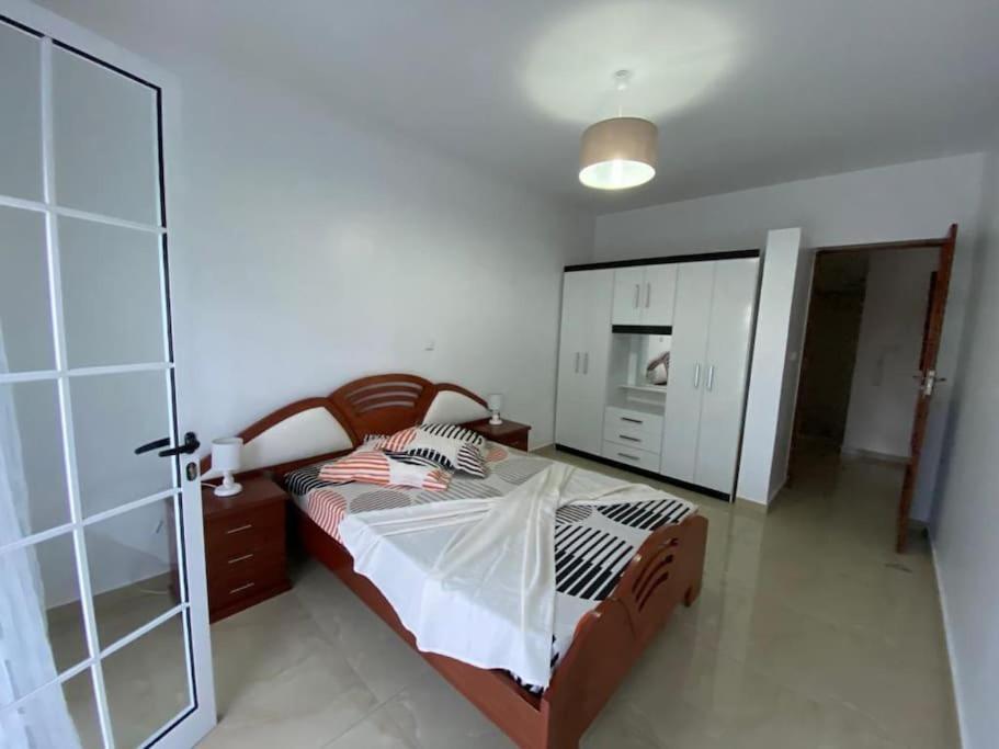 1 dormitorio con 1 cama y puerta de cristal en Maison familiale à Tarrafal., en Tarrafal