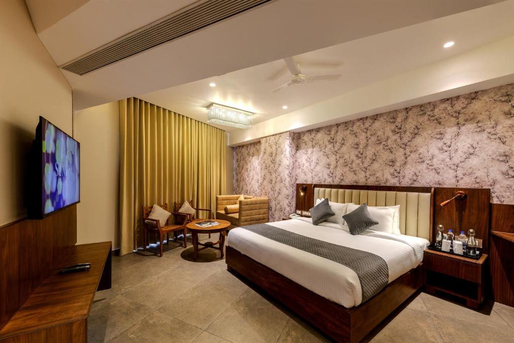 une chambre d'hôtel avec un lit et une télévision dans l'établissement Sundex Hotel, à Thanjavur