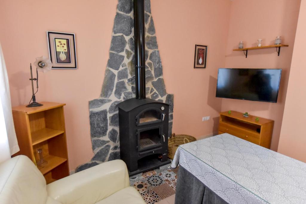 uma sala de estar com um fogão a lenha num quarto em Casa Coro by SIERRA VIVA em Cortelazor