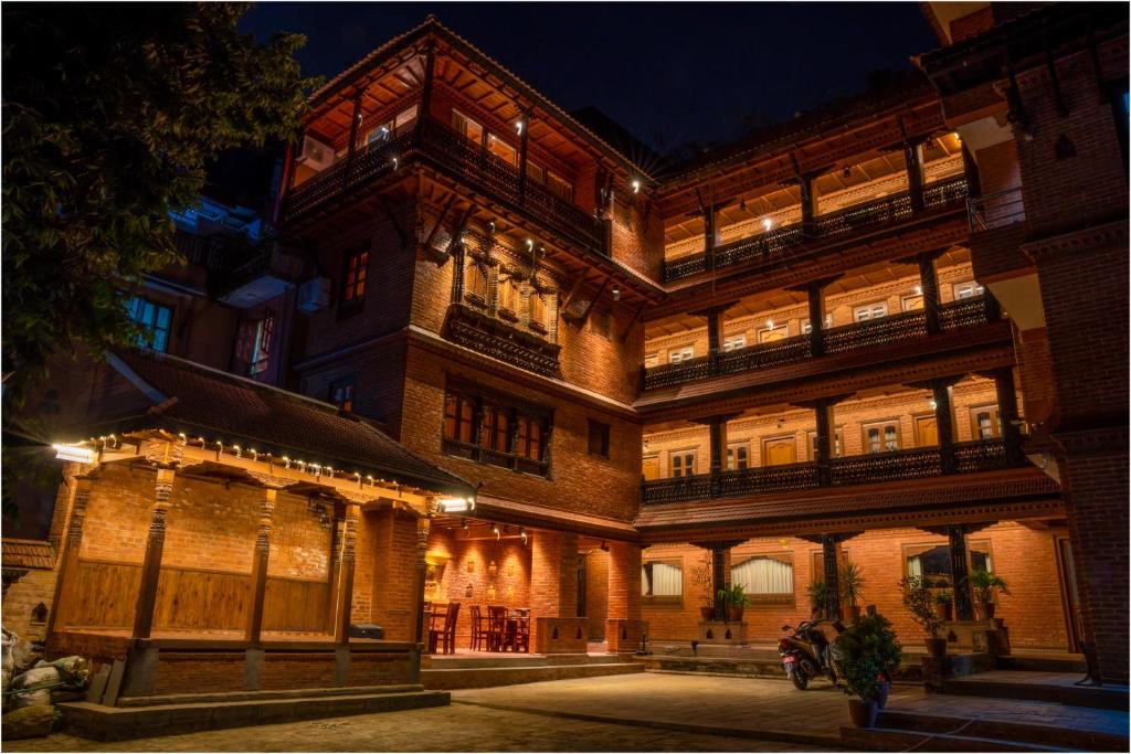 ein großes Backsteingebäude mit Nachtbeleuchtung in der Unterkunft Nag Pukhu Guest House in Bhaktapur