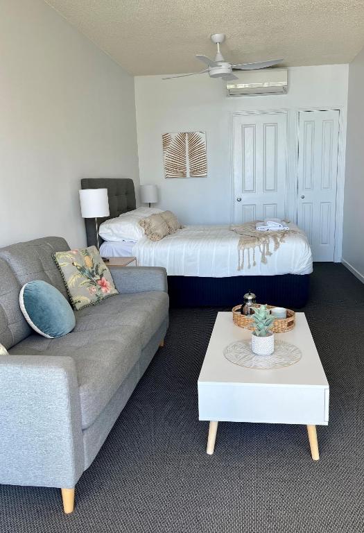 un soggiorno con divano e letto di Top Floor Beachside Apartment in the Heart of Mooloolaba a Mooloolaba