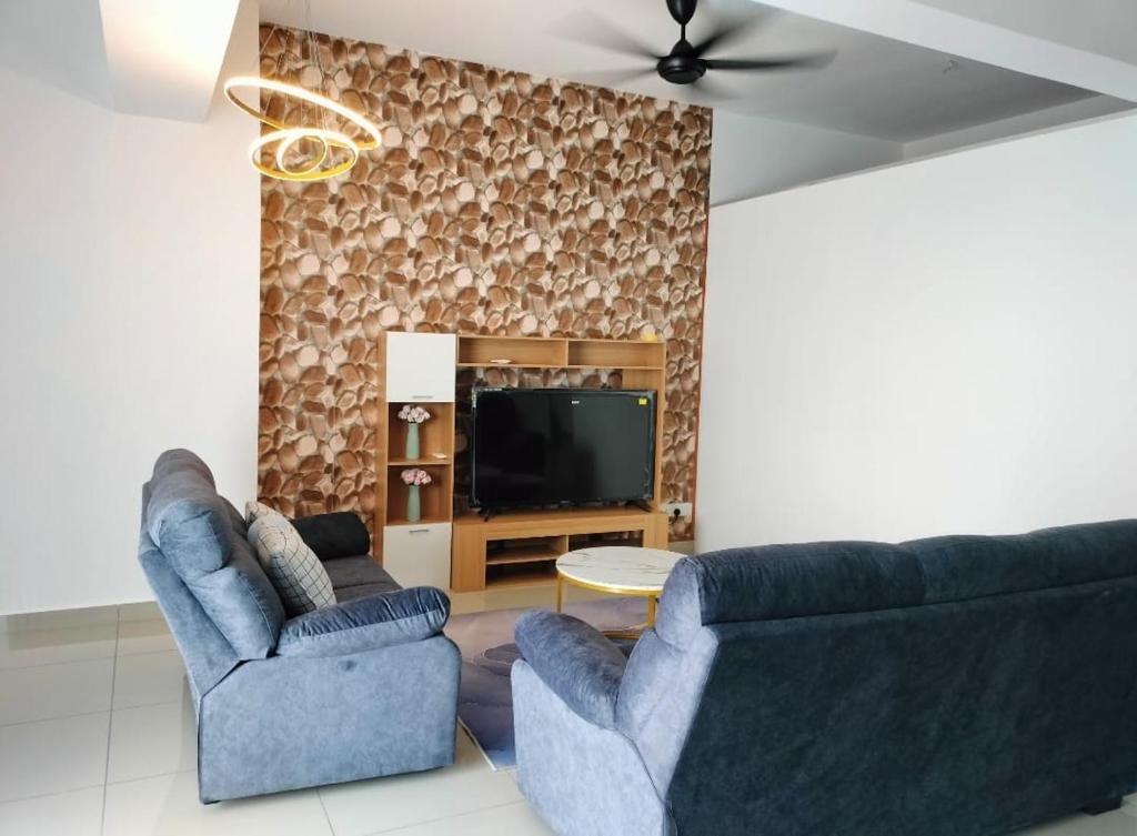 uma sala de estar com duas cadeiras azuis e uma televisão em Travelers HomestySitiawan b-30-6 The Venus Aparment em Seri Manjung