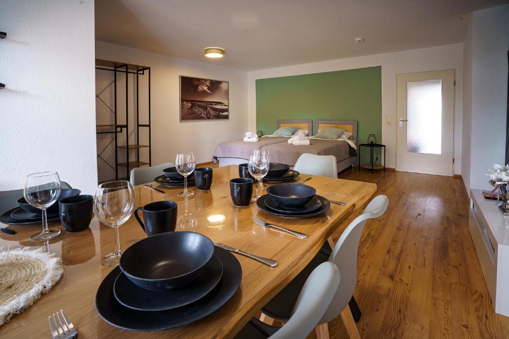 a dining room with a table with chairs and wine glasses at ImmoStay #2 -Moderne Wohnung mit zwei Balkonen, WLAN & Parkmöglichkeit in Stuhr