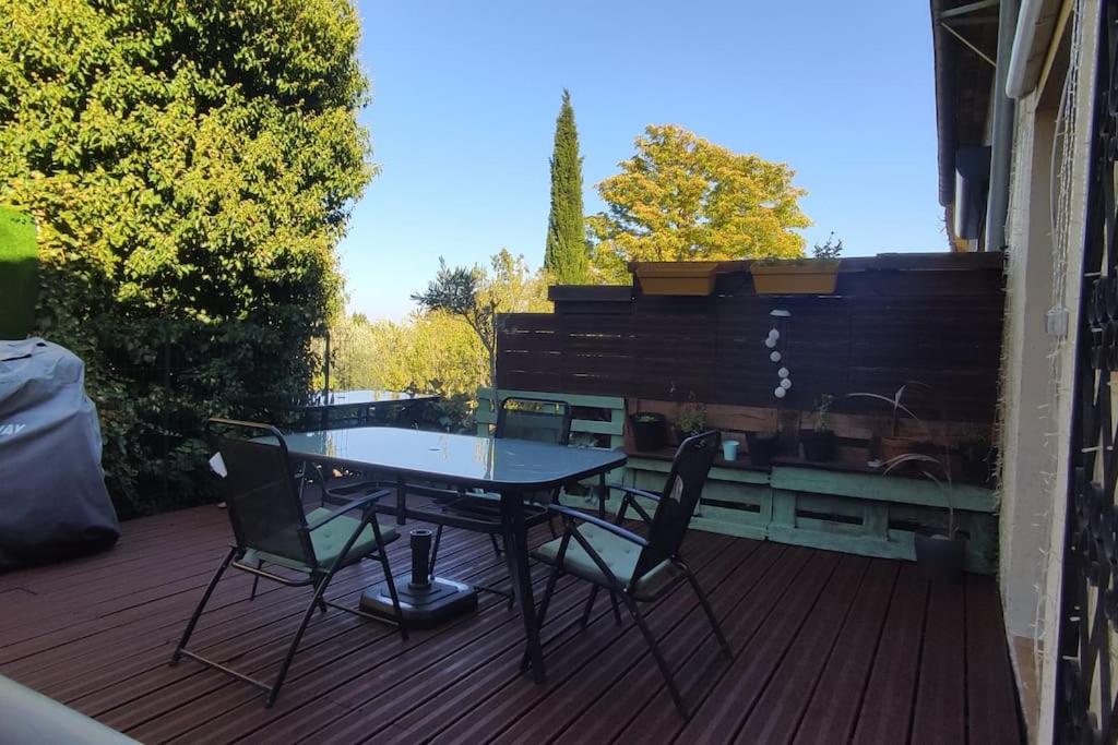 un patio con mesa y sillas en una terraza en Welcome, Bienvenue, Chez Charly! en Nébian