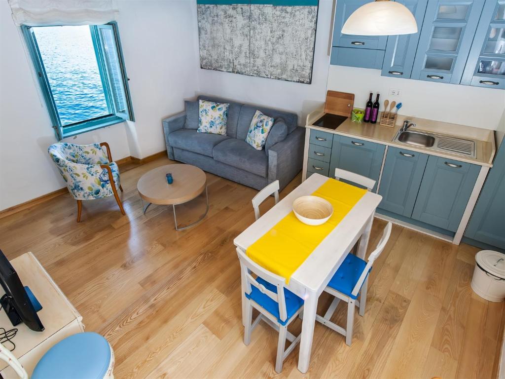 una cucina e un soggiorno con tavolo e divano di Apartment Pastello a Rovigno (Rovinj)