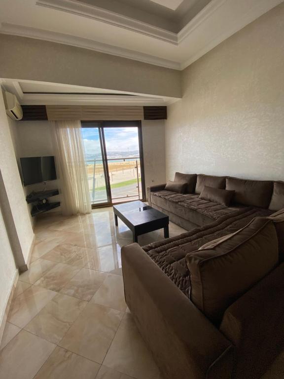 een woonkamer met een bank, een tafel en een televisie bij Appartement Playa de Tanger/ Marina Bay in Tanger
