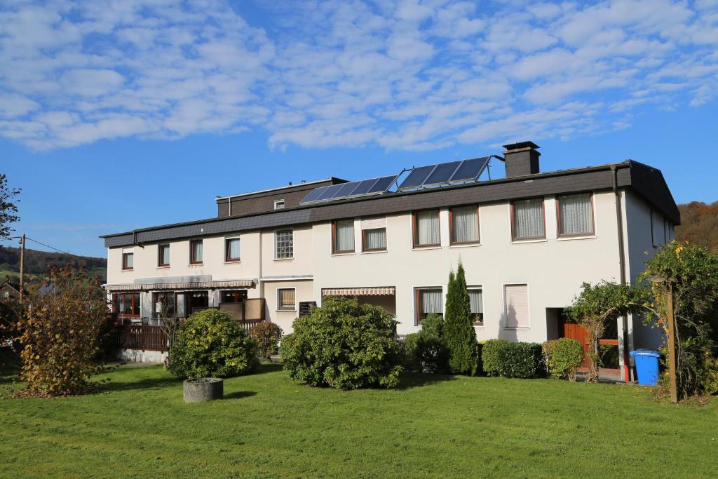 une maison avec des panneaux solaires sur le toit dans l'établissement Hotel Bechtel, à Burbach