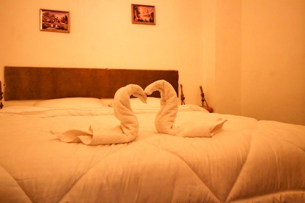 two white swans sitting on a bed at Petra NefNaf Hostel in Wadi Musa