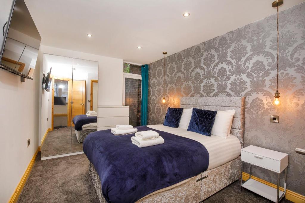 a bedroom with a large bed with a purple blanket at The Haven At The Lawrence Apartments in York