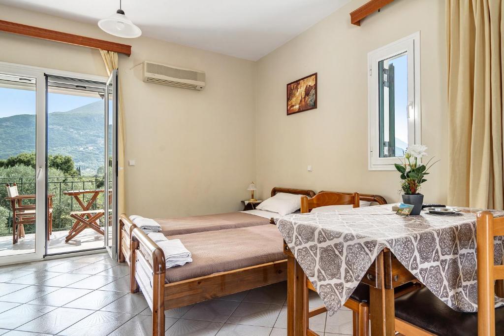 una camera con letto e tavolo e un balcone di Daratos studio 1 a Cefalonia