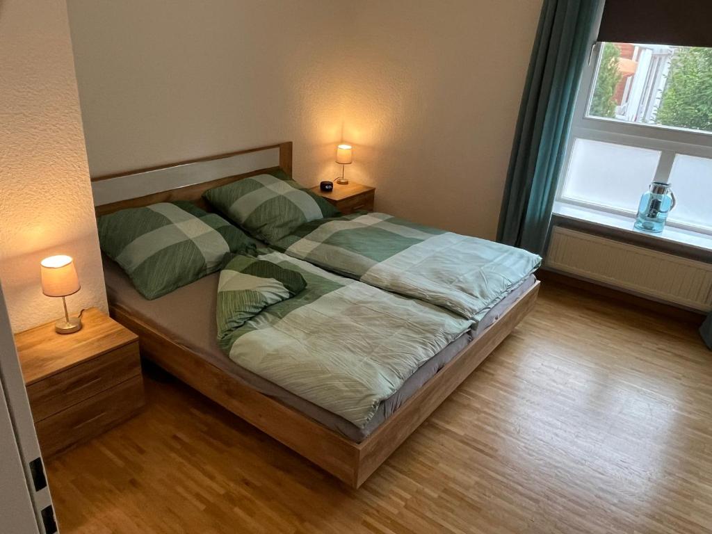 a bedroom with a bed with two lamps on it at Ferienwohnung Stadtgracht in Nordhorn