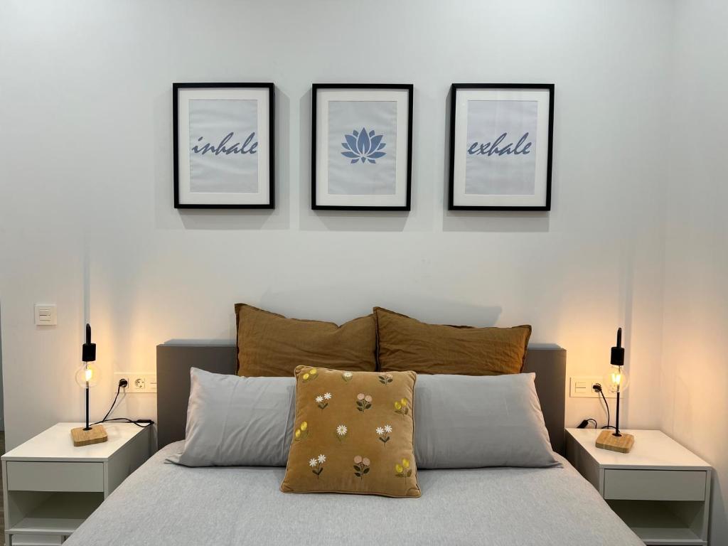 a bedroom with a bed with four pictures on the wall at Loft RioArga. Comodidad y Estiloa a 5 min Centro. Nuevo!!! in Pamplona