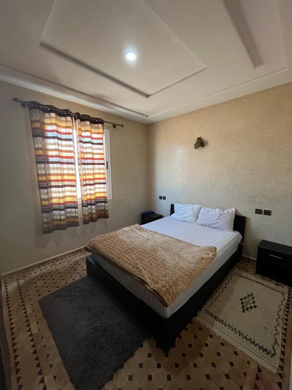 a bedroom with a bed and a window at Stone house in Mirleft