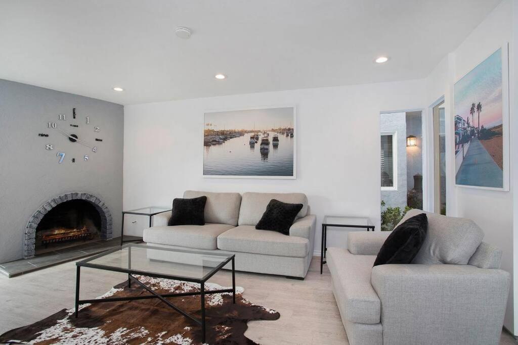a living room with two couches and a fireplace at Newport Beach Living (1 blk to beach and 25 min to Disney) in Newport Beach