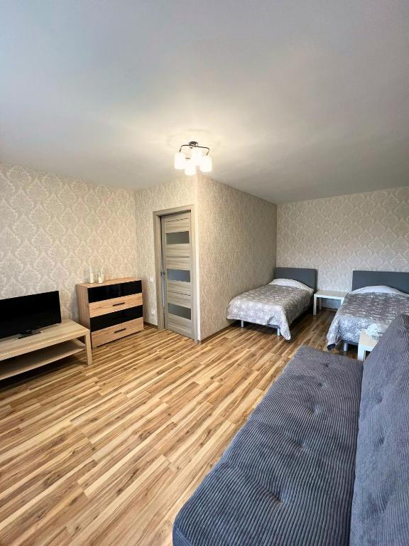 a room with two beds and a flat screen tv at Zemgales ielas apartamenti in Jēkabpils
