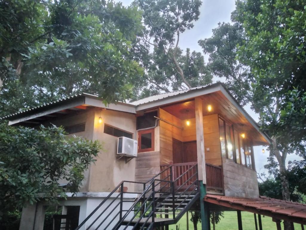 une petite maison avec une terrasse couverte et une terrasse dans l'établissement Green Herbal Ayurvedic Eco-Chalets, à Galle