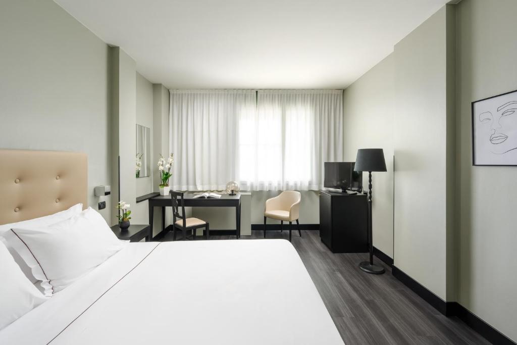 una camera d'albergo con letto e scrivania di Hotel King, by R Collection Hotels a Varedo