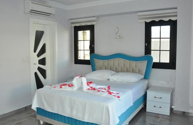 a bedroom with a blue and white bed with red bows at Villa Sultan,s Palace in Fethiye