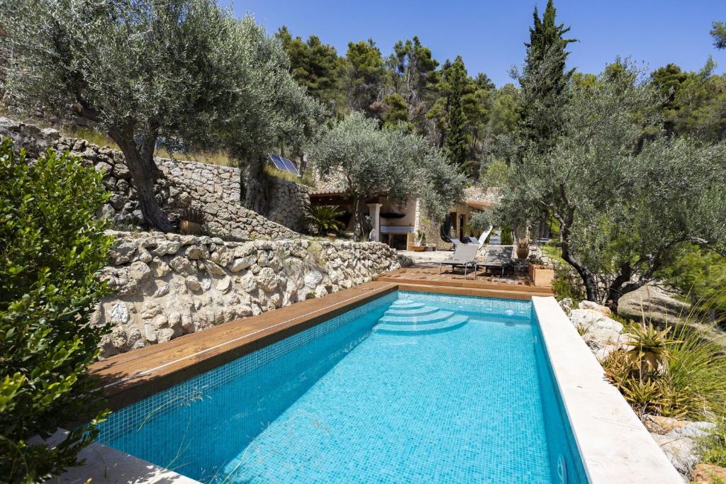 a swimming pool in front of a stone wall at Villa Son 3 in Mancor del Valle