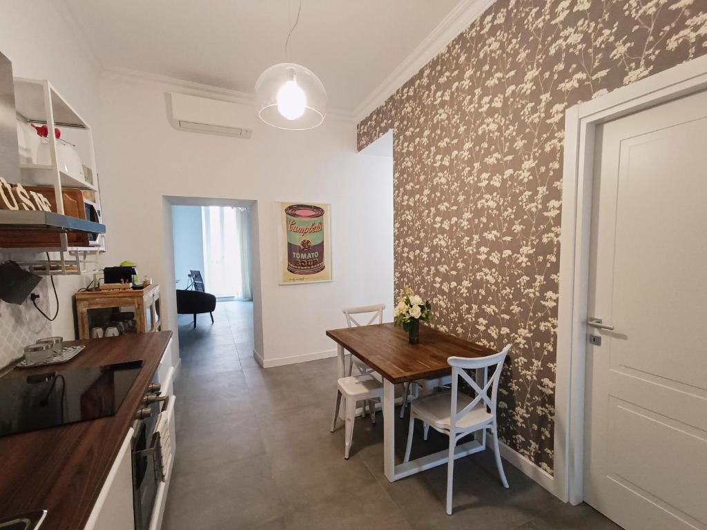 eine Küche und ein Esszimmer mit einem Tisch und einer Wand in der Unterkunft La tua casa a Piazza del Popolo in Rom