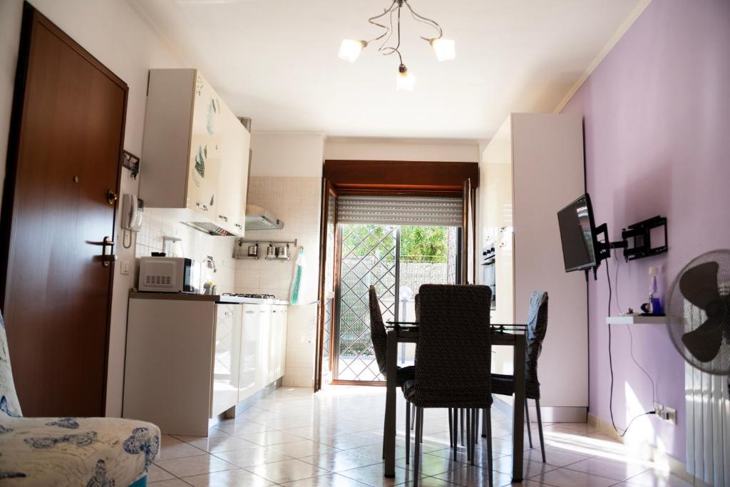 uma cozinha e sala de jantar com mesa e cadeiras em Red House Tiburtina em Roma
