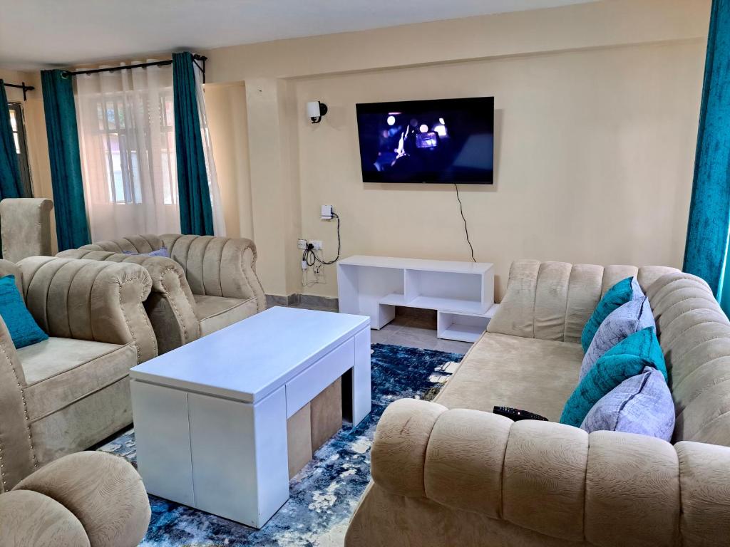 a living room with two couches and a tv at Upperhill suites in Kisii