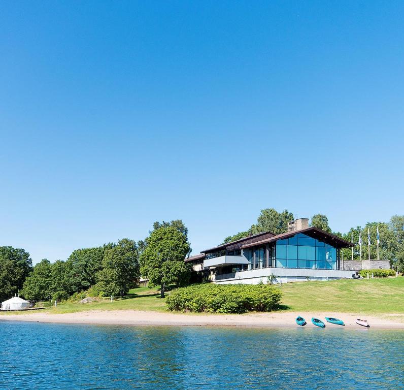 a house on the shore of a body of water at Skåvsjöholm Hotell och Möten in Åkersberga