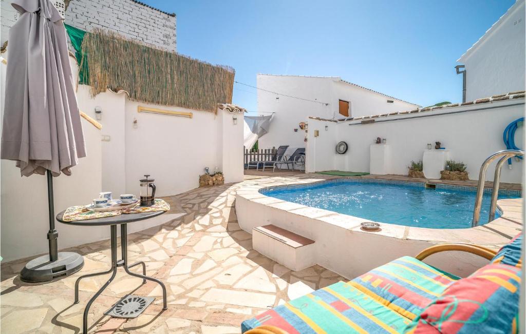 une terrasse avec une piscine, une table et un parasol dans l'établissement 5 Bedroom Nice Home In Villanueva De Algaidas, à Villanueva de Algaidas