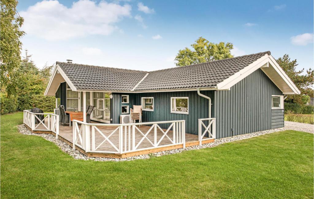 a green house with a deck in the yard at Awesome Home In Sydals With Sauna in Skovbyballe