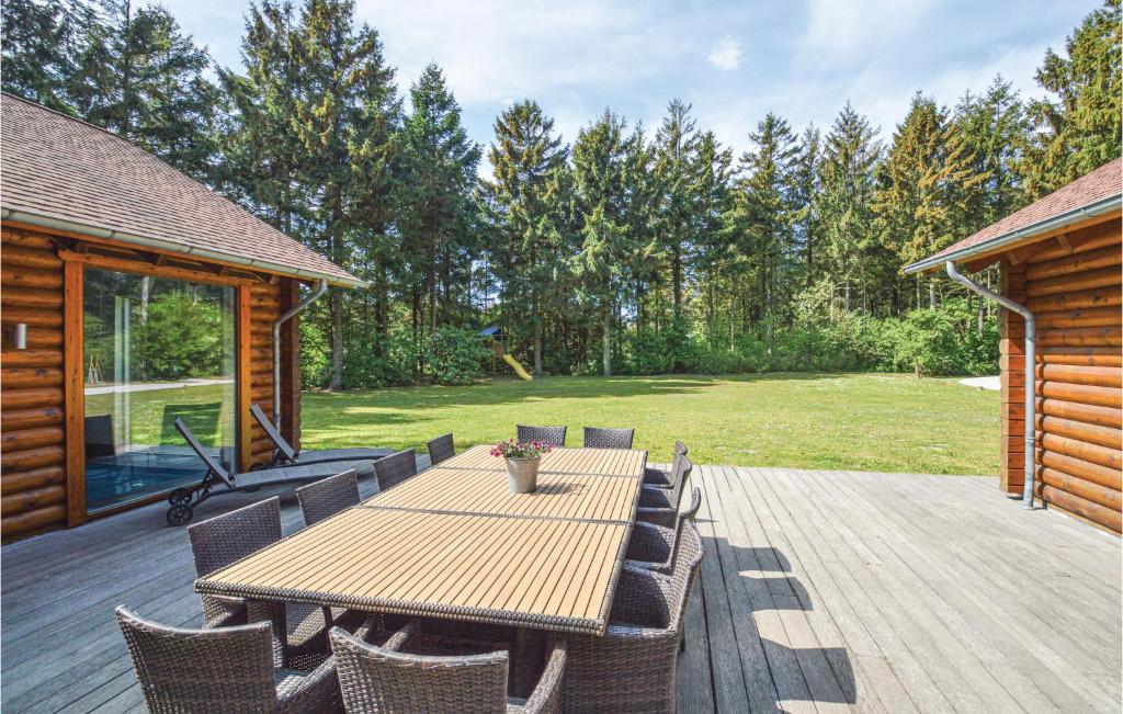 a wooden deck with a wooden table and chairs at Stunning Home In Lkken With 8 Bedrooms, Sauna And Indoor Swimming Pool in Lønstrup