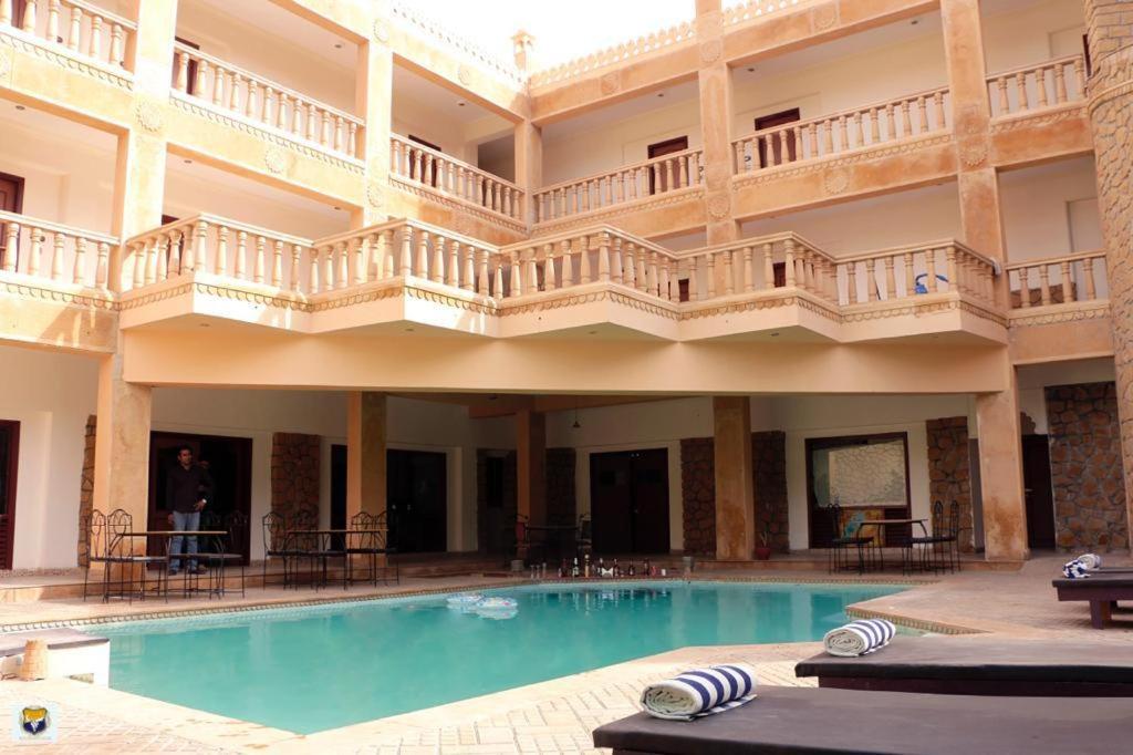 a large hotel with a swimming pool and a balcony at Hotel Deoki Niwas Palace in Jaisalmer