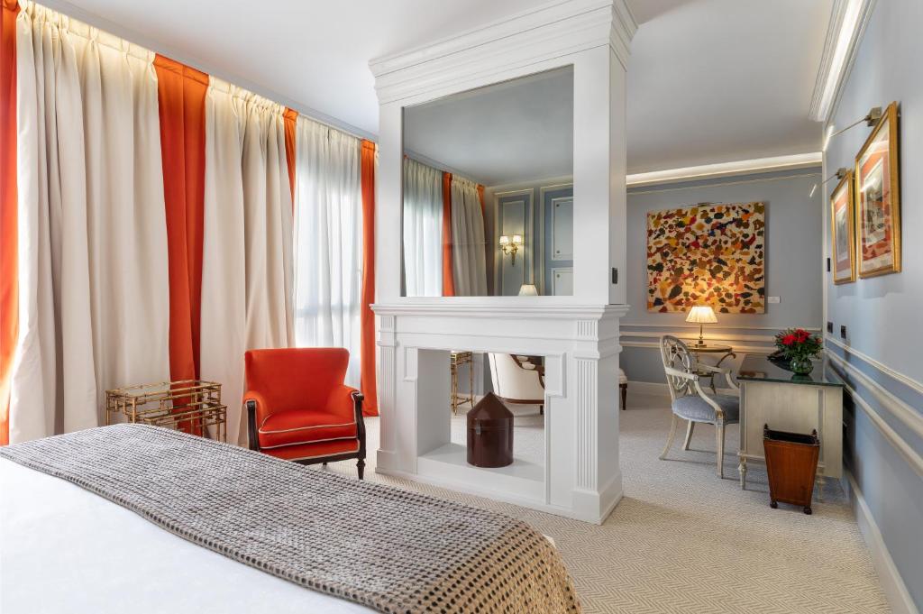 Schlafzimmer mit einem Bett, einem Kamin und einem Schreibtisch in der Unterkunft Wellington Hotel & Spa Madrid in Madrid