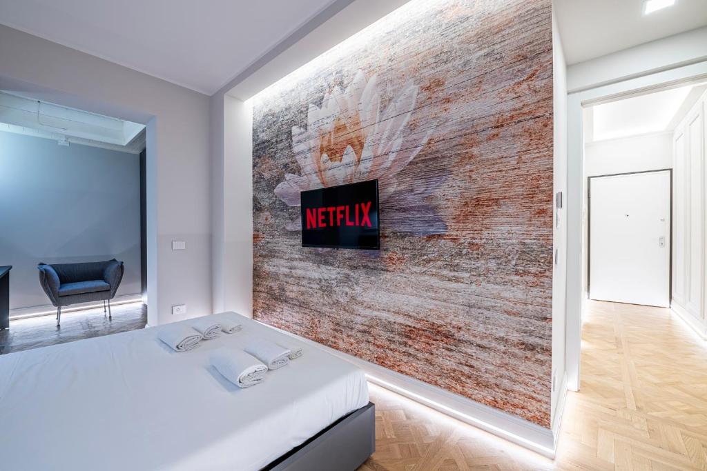 1 dormitorio con pared de ladrillo y TV en la pared en Beccaria - Florence luxury Apartment, en Florencia