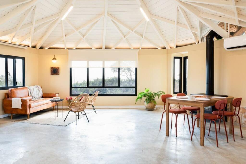 een woonkamer met een tafel en stoelen en een bank bij בית בהר- בקתה יפיפיה בקצה הגלבוע in Sede Terumot