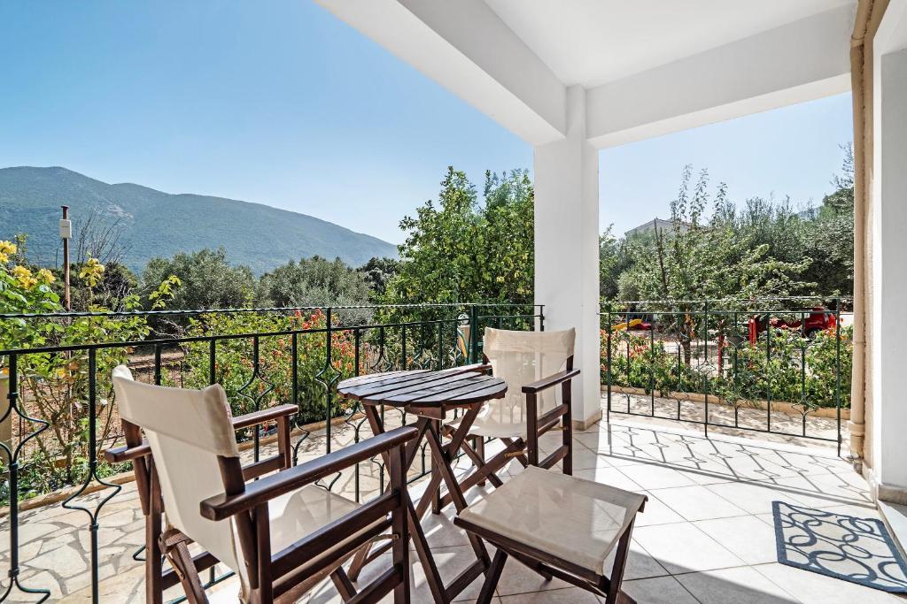 a patio with a table and chairs and mountains in the background at Daratos studio 4 in Kefallonia