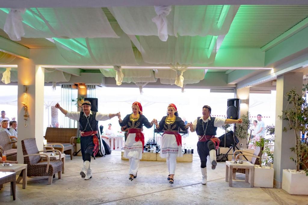 a group of people dancing in a room at Glaros Beach Hotel in Hersonissos