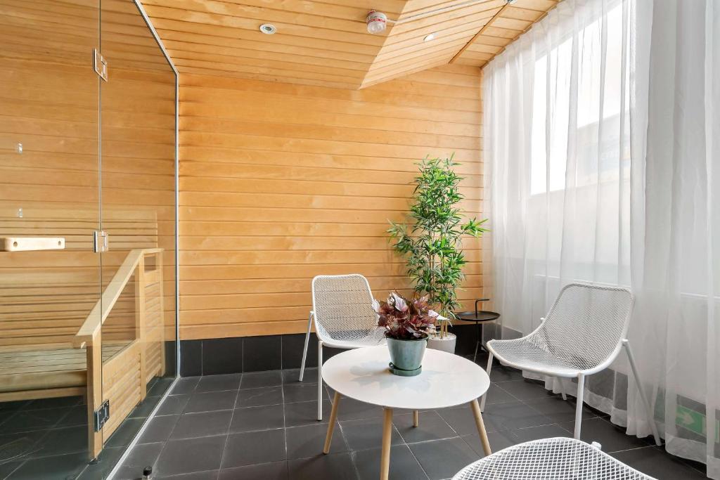 a room with a table and chairs and a wooden wall at Best Western Plus Sthlm Bromma in Stockholm