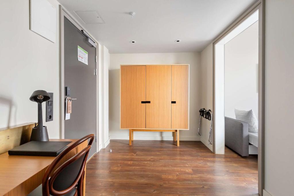 a room with a wooden cabinet and a bed at Best Western Plus Sthlm Bromma in Stockholm