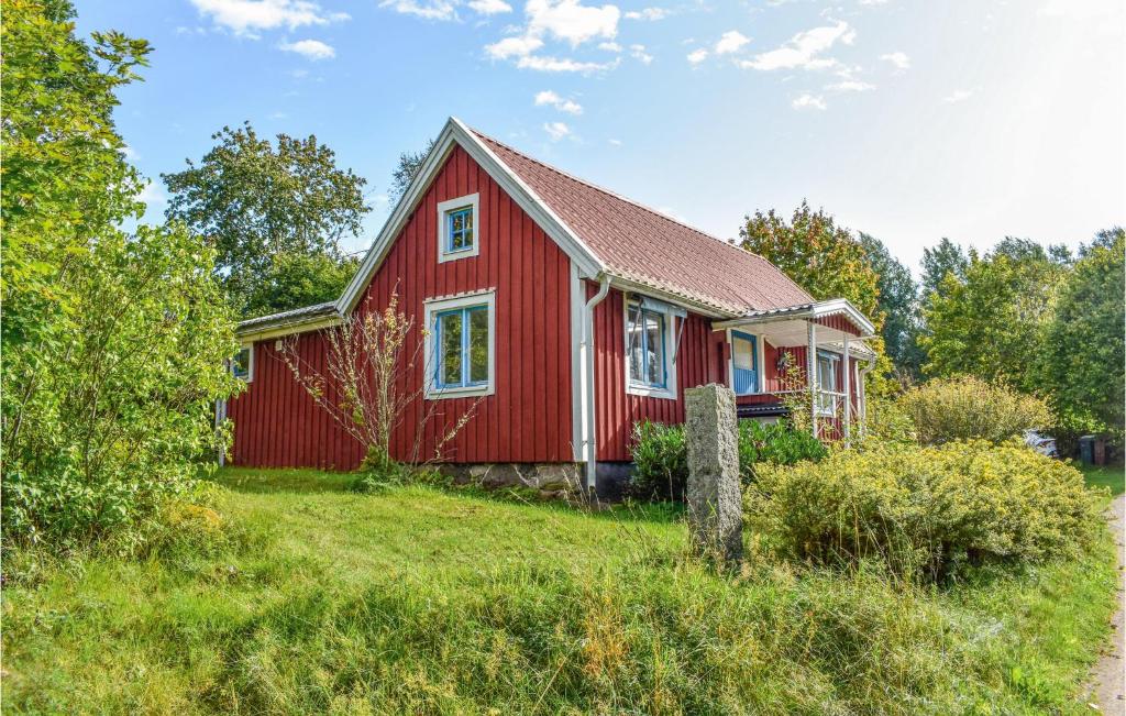 une maison rouge au milieu d'un champ dans l'établissement Cozy Home In Vissefjrda With House A Panoramic View, à Vissefjärda