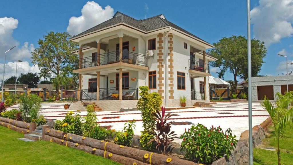 a large white house with a garden in front of it at Luxury Villa Garden in Dar es Salaam