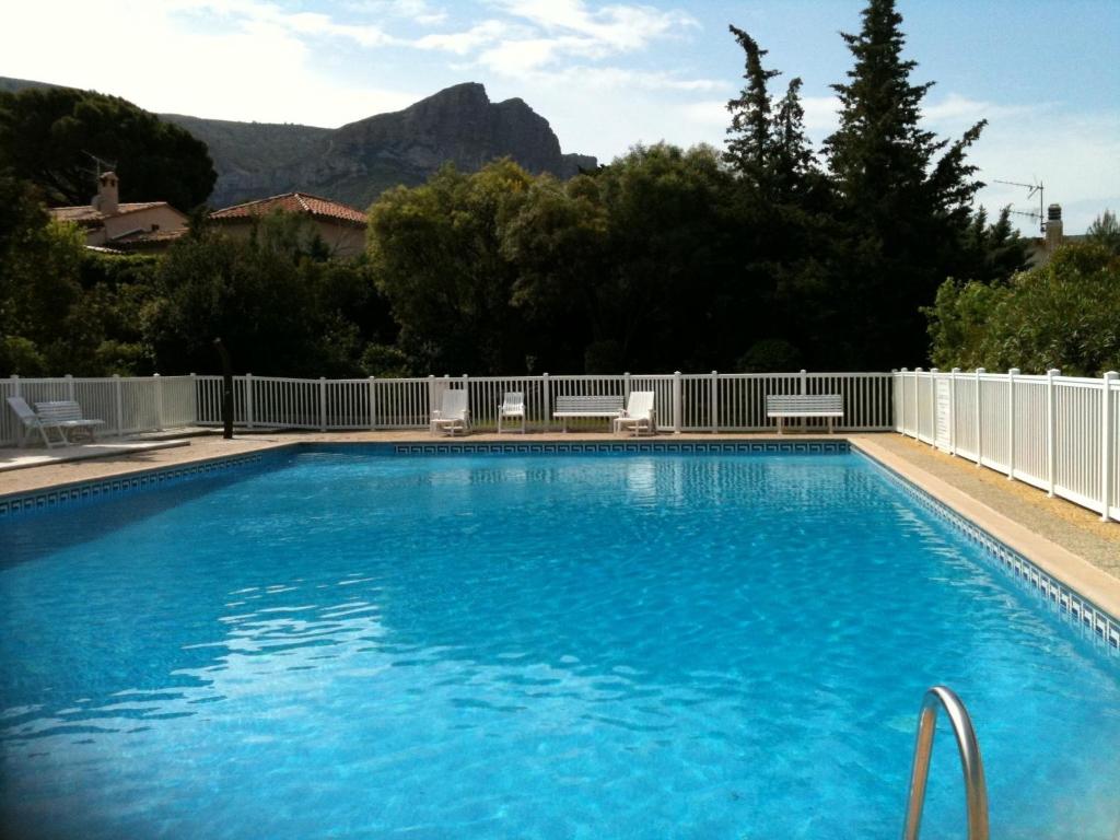 a large blue swimming pool with a white fence at Villa Soledad in Cassis