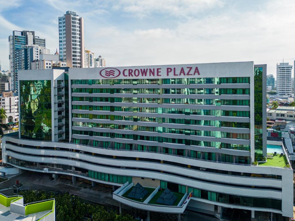 un grand immeuble de bureaux avec un panneau sur celui-ci dans l'établissement Crowne Plaza Panama, an IHG Hotel, à Panama City
