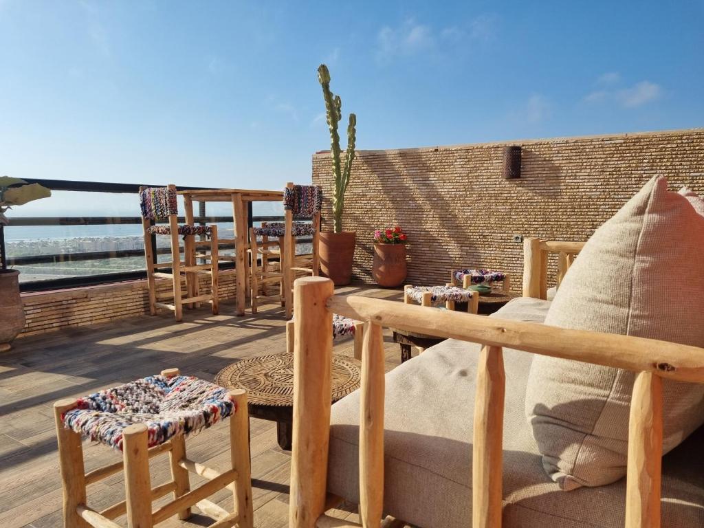 a patio with chairs and tables on a deck at Riad Searenity in Tamraght Ouzdar