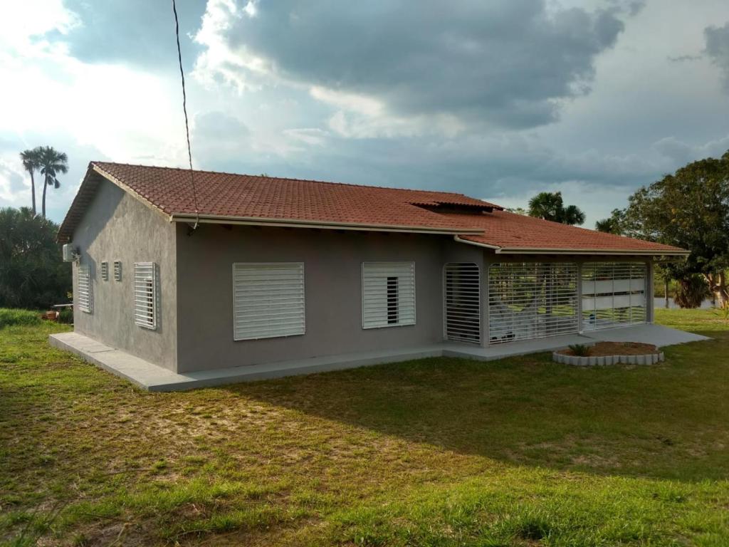 a small house with a grass yard in front of it at Pousada Tia Míria 