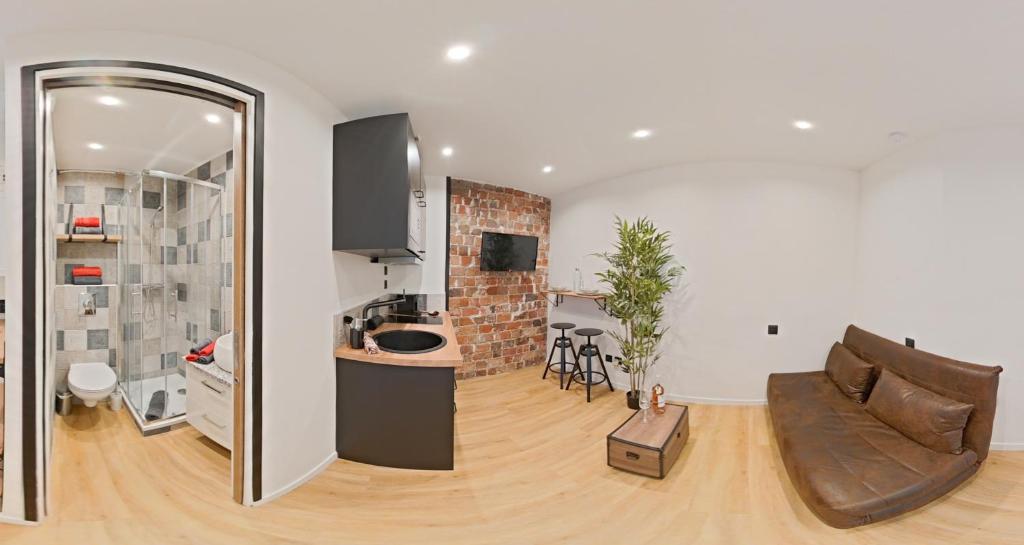 un salon avec un canapé et une cuisine dans l'établissement T1 PRESTIGE PARIS MONTMARTRE, à Paris