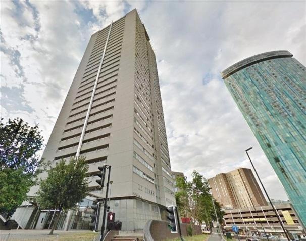 um edifício alto numa rua da cidade com um semáforo em Private Room in Modern Shared Apartment, Each with Kitchenette, Central Birmingham em Birmingham