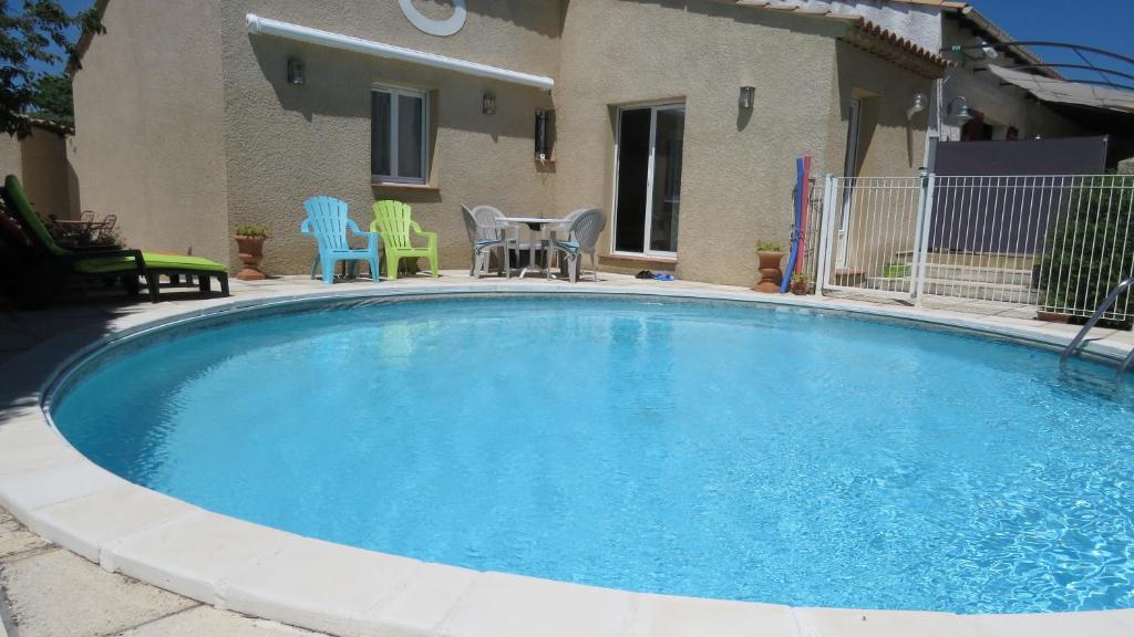 een groot zwembad met stoelen en een tafel bij La Saugelia votre maison avec piscine privative ! in Mouriès