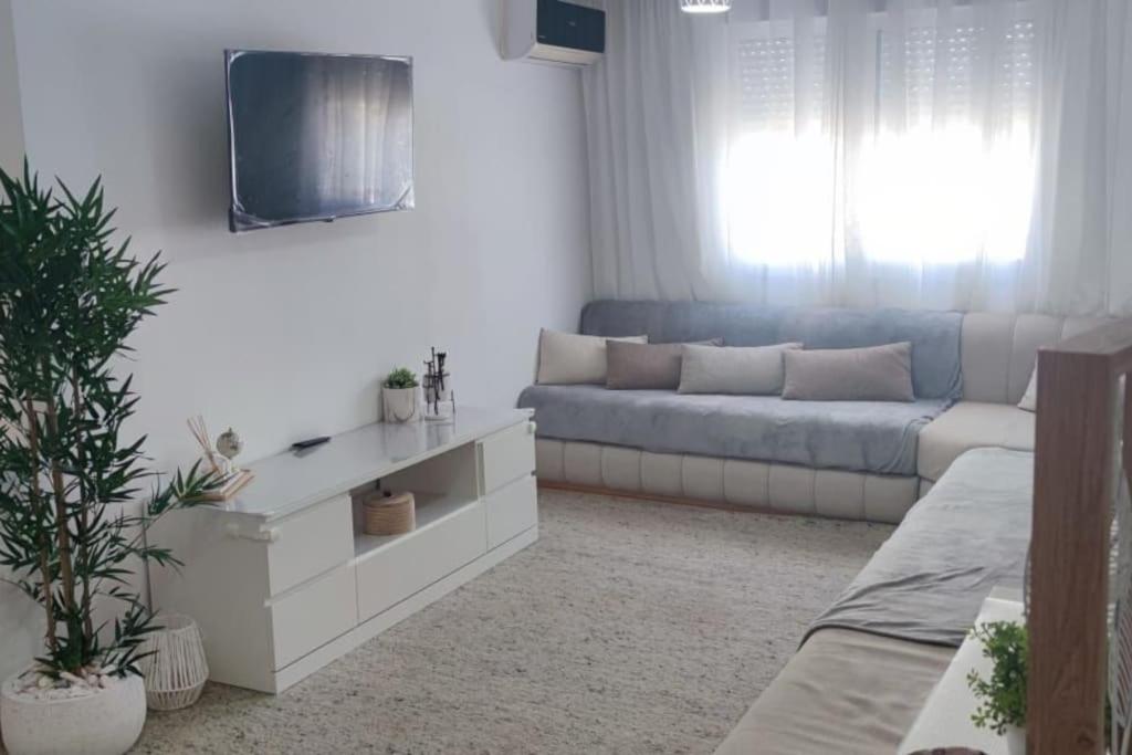 ein Wohnzimmer mit einem Sofa und einem TV in der Unterkunft la maison du repos in Oulad Kerroum
