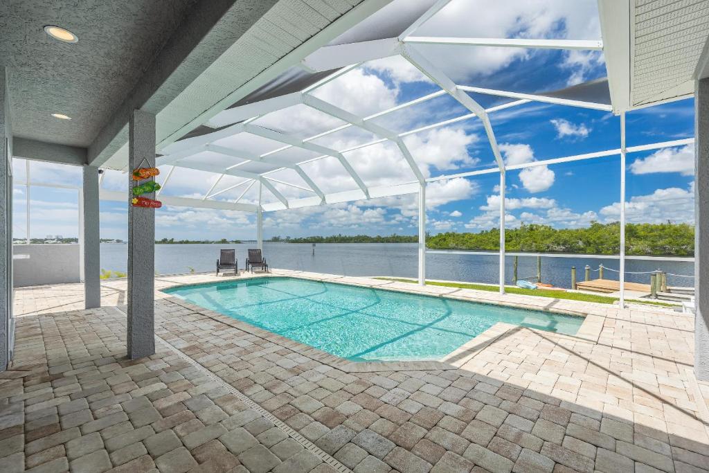 a swimming pool with a white canopy on a house at Heaven Found! Stunning River Views & Pool - Villa Island Sunset - Roelens Vacations in Fort Myers